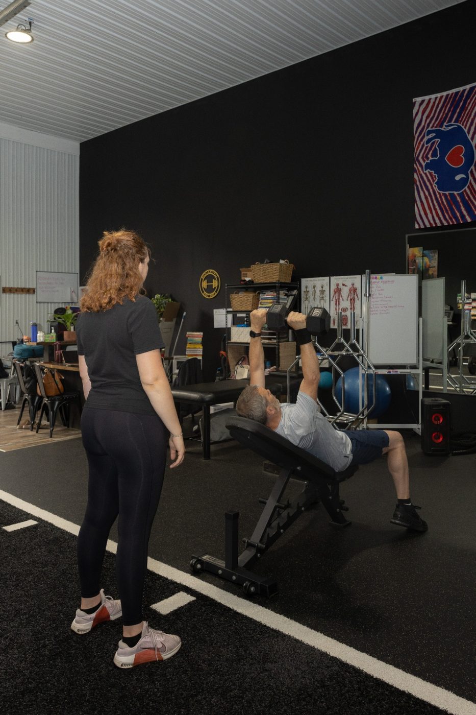 RockeyFit trainer coaching a client through a dumbbell bench press in Hamburg, NY