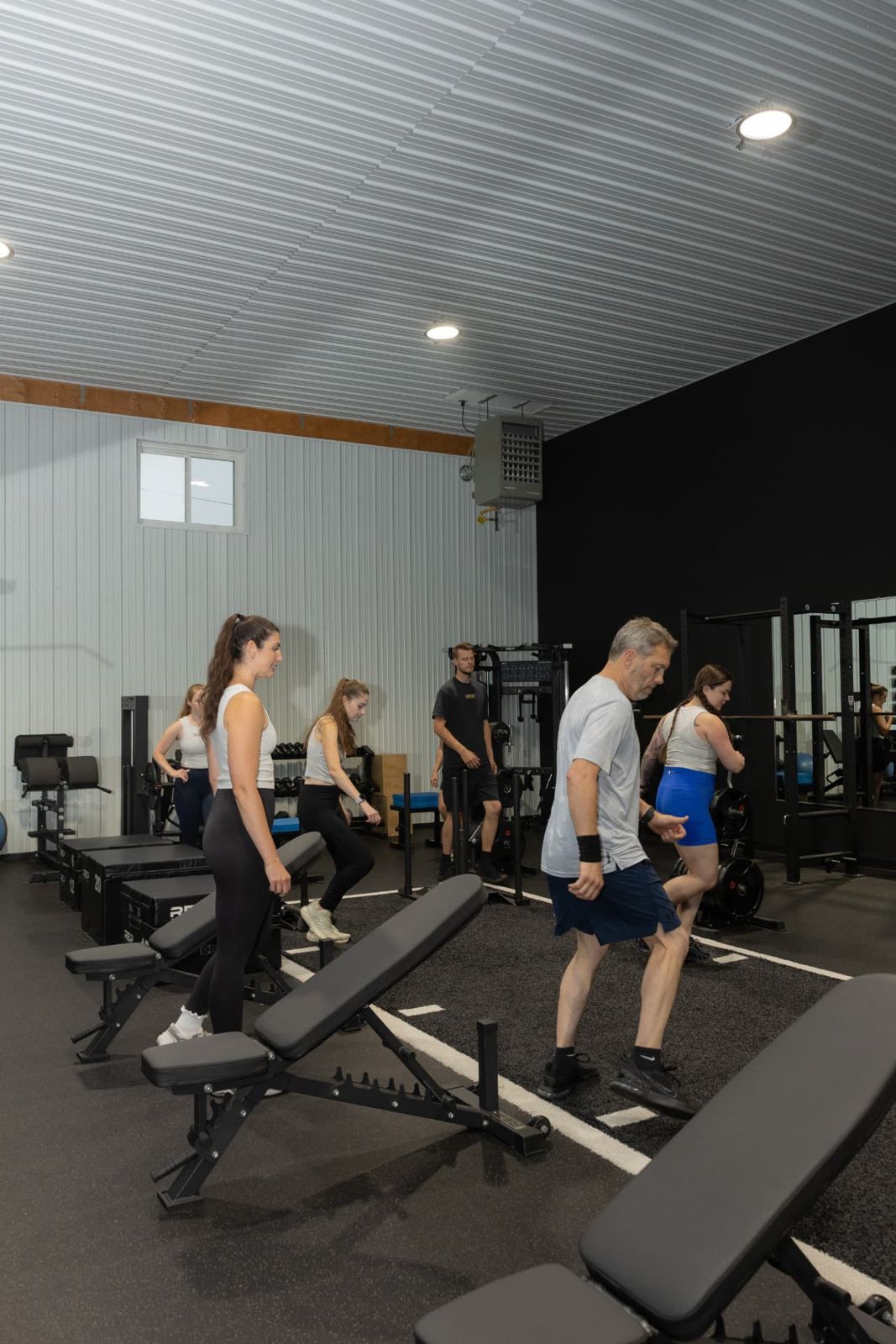 RockeyFit members performing coached step-ups on benches